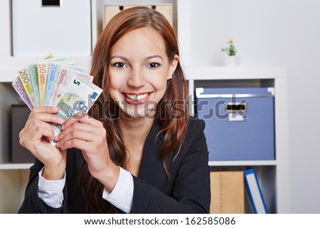 Happy smiling business woman with Euro money bills in the office