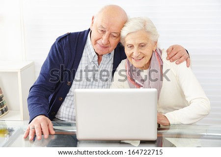 Senior couple using ecommerce in internet with laptop computer
