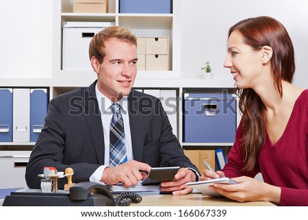 Smiling woman talking to tax consultant in his office