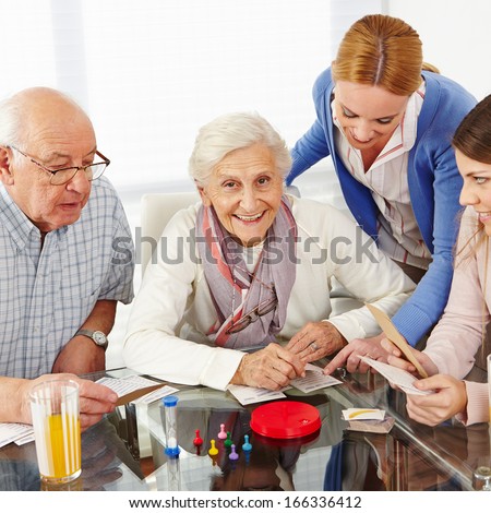 Happy family with senior couple playing parlor games