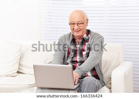 Happy senior citizen man working with computer in the internet