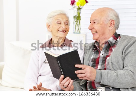Senior citizen couple reading a book in a retirement home