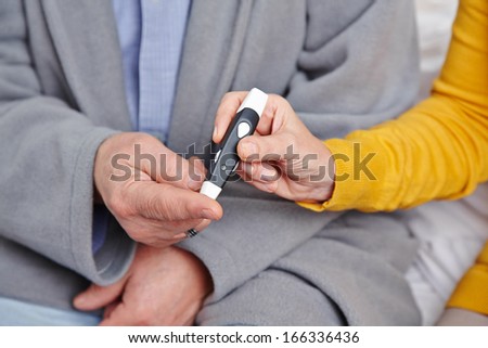 Hand of senior man with diabetes getting blood glucose monitoring