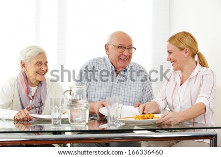 Happy Family With Senior Couple Eating Lunch At Table