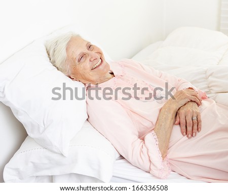 Beddridden senior citizen woman in a nursing home smiling