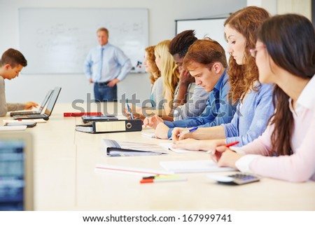 Many different students learning in a class in university