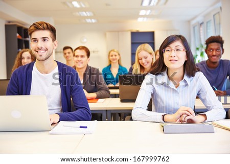 Many Smiling Students Learning In A University Class