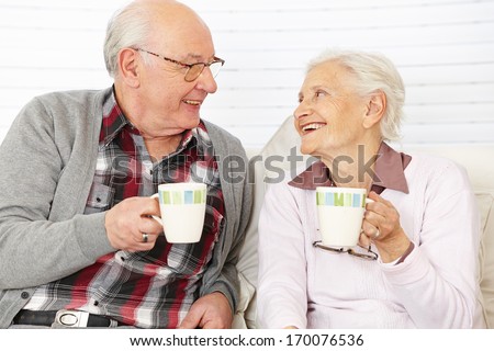 Happy senior citizen couple drinking coffee together