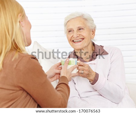 Family with senior woman drinking coffee in a retirement home
