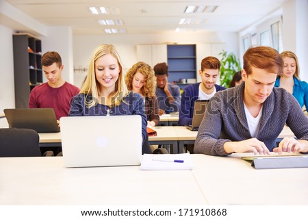 Many Students In School Working With Computers And Tablet Pcs