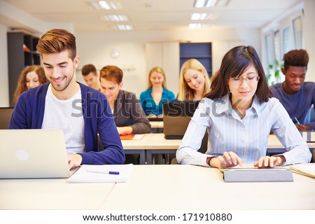 Computer Class In University With Many Students With Laptops And Tablet Pcs
