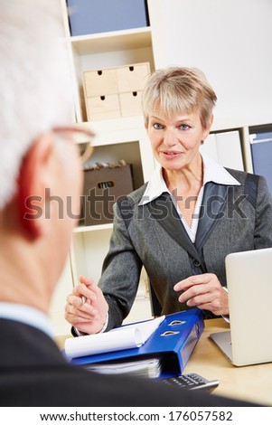 Senior man listening to female consultant in a bank