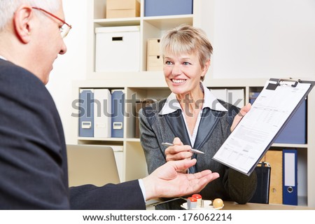 Senior business man writing signature under a contract on a clipboard