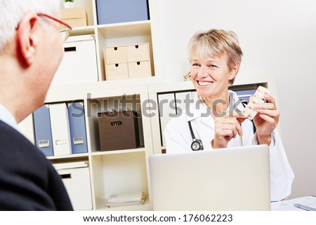 Elderly doctor giving pills to senior man in her office