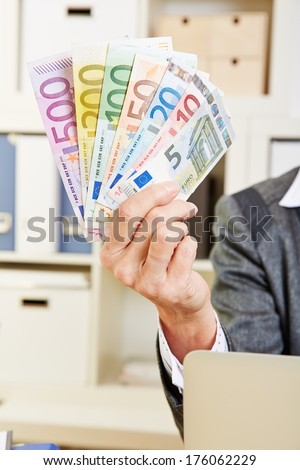 Fan of Euro money in hand of an elderly woman in the office