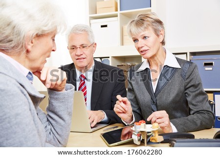 Elderly senior woman at communication over financial issues in a bank