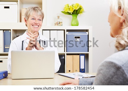 Female doctor talking with senior patient in her office