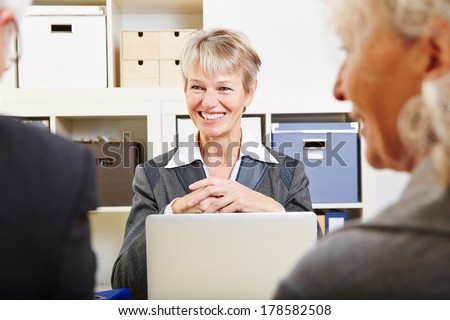 Senior couple getting financial advice from woman in a bank