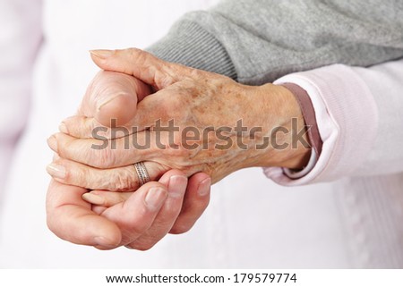 Two happy senior citizens holding their hands close