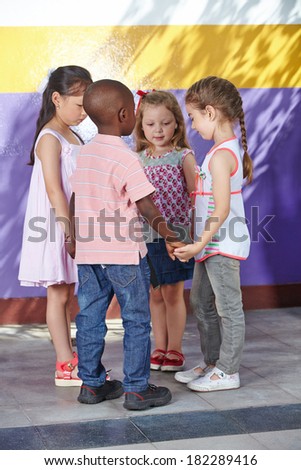 Four children dancing in circle in a kindergarten class