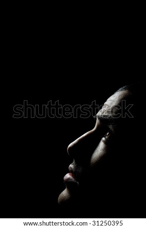 Dark portrait of a man looking up