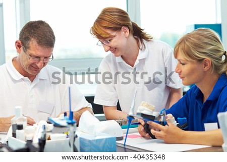 Three dental technicians working in a dental laboratory
