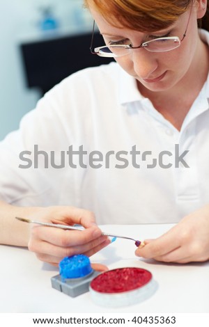 Dental technician working on a cap for a tooth