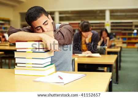 Student sleeping in reading room of university library