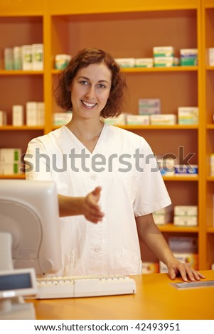 Pharmacist behind counter reaching out with her hand