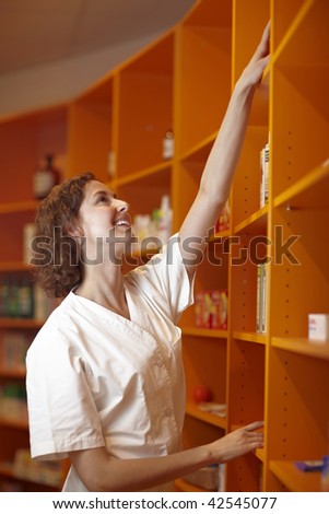 Female pharmacist looking for medicine in shelf