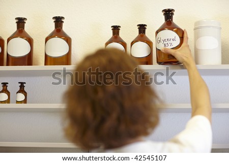 Pharmacist in lab holding bottle with glycerol