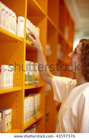 Female pharmacist looking for medicine in shelf