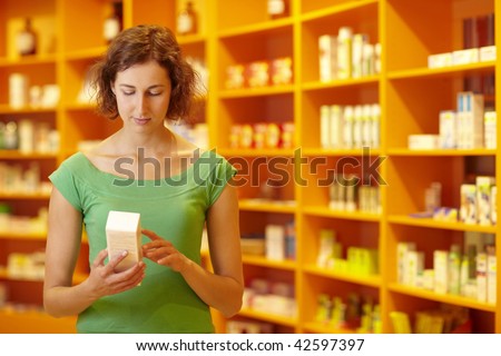 Customer in pharmacy reading information on medicine