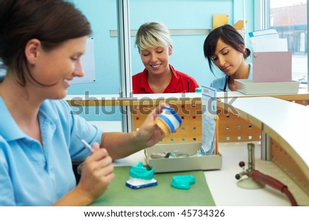 Three dental technicians working in a dental laboratory