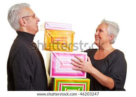 Two happy senior citizens with colorful gifts