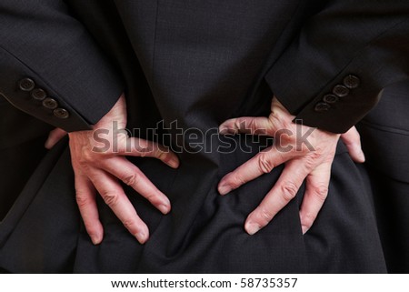 Elderly businessman holding his hand to his aching back