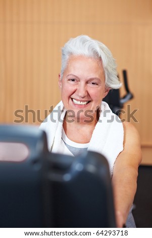 Happy smiling senior woman exercising in a gym