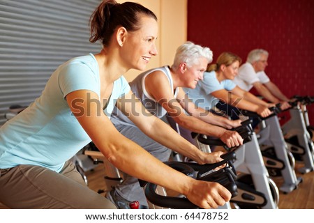 People in a gym sitting on bikes