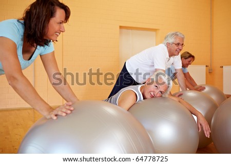 Exhausted woman in fitness class laying on exercise ball