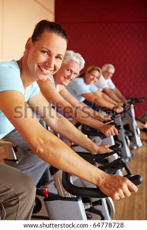 People in a gym sitting on bikes