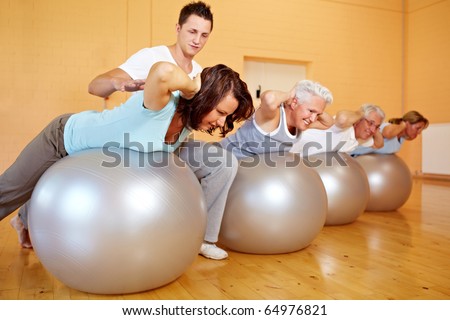 Fitness trainer in a gym teaching back exercises