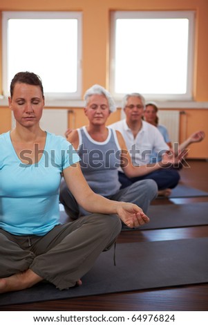 Yoga group in gym doing meditation exercises