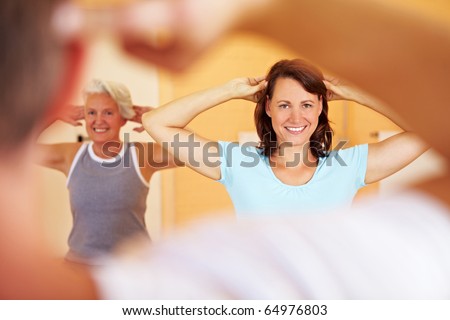 Group in a gym doing gymnastics with a fitness trainer