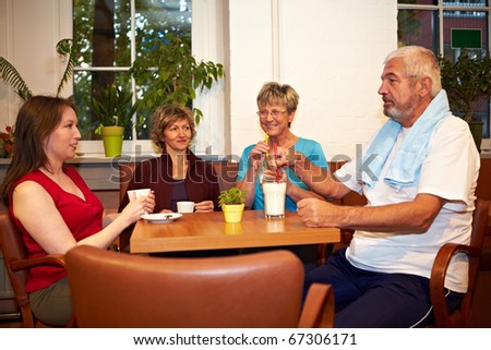Mixed group drinking coffee in a gym