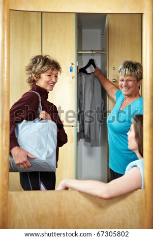 Three happy woman chatting in locker room