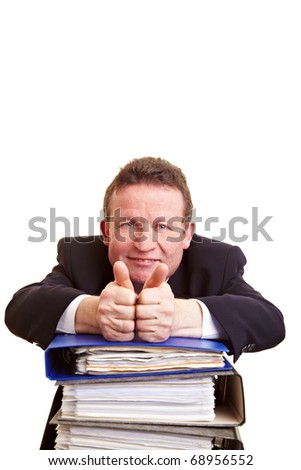 Smiling elderly manager with files holding his thumbs up