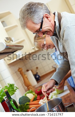 Two happy senior people cooking in the kitchen