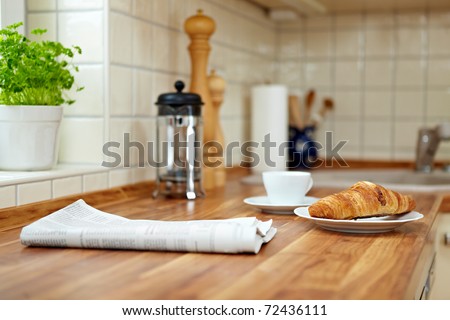 Croissant and a cup of coffee on a kitchen counter