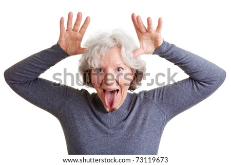Silly old senior woman showing her tongue and making a face