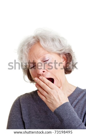 Old senior woman yawning with hand in front of her mouth